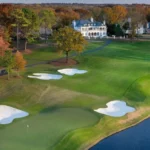 Aerial view of Quail Hollow Club during the PGA Championship 2025 with pristine greens and white sand bunkers.